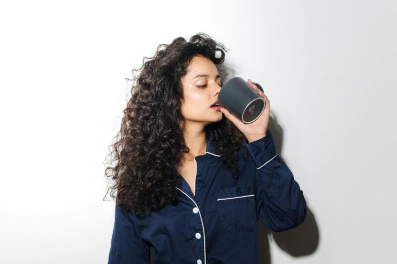 Žena pije kavu iz šalice – utjecaj kofeina na starenje i izgled kože